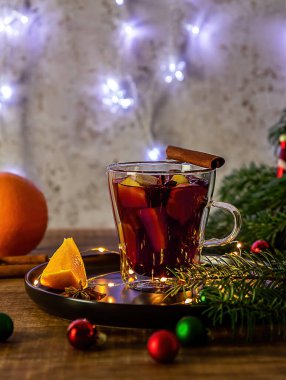 Sıcak şarap ve Noel süslemeleriyle dolu bir bardak. Dikey yönelim