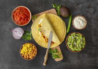 Tortilla dürümü ya da mısır, fasulye, yeşillik ve ev yapımı guacamole ile dürüm. Vejetaryen sağlıklı yemek, Meksika mutfağı.