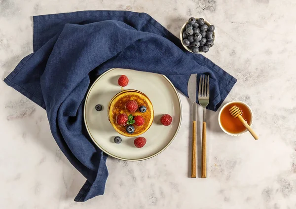 Leckere amerikanische Pfannkuchen mit Himbeeren, Blaubeeren und Honig. Draufsicht, Marmortisch. — Stockfoto