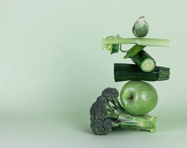 Verduras verdes frescas y frutas sobre fondo verde. Equilibrio equilibrio alimentario flotante. —  Fotos de Stock