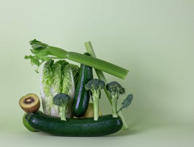 Yeşil arka planda taze sebzeler ve meyveler. Dengeli yüzen yiyecek dengesi.