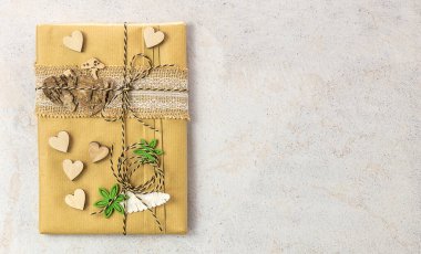 Tahta süslemelerle el işi kağıda sarılmış kitap. Sıfır atık, çevre dostu paketleme hediyesi.