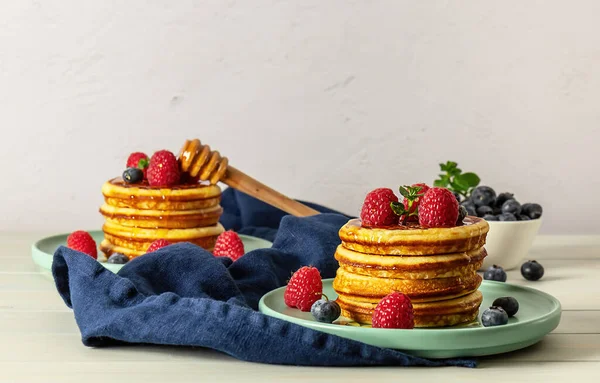 Tasty american pancakes with raspberries, blueberries, and honey. — Stock Photo, Image