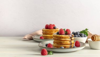 Ahududulu, yaban mersinli ve ballı leziz Amerikan krepleri. Fotokopi alanı olan aile kahvaltısı kavramı.