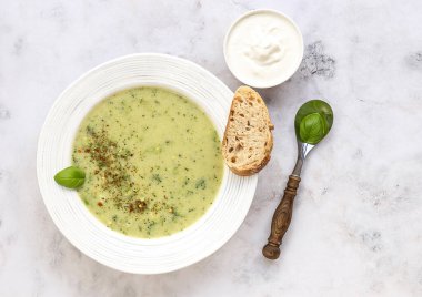 Kremayla servis edilen brokoli kremalı çorba ve hafif mermer masada taze ekmek. Sağlıklı vejetaryen gıda konsepti. Üst görünüm, alanı kopyala
