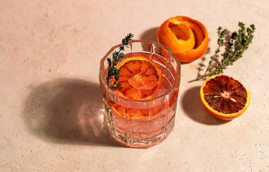 Güneşli bir günde kırmızı kan portakallı ve buzlu pembe cin kokteyli. Alkolik, ferahlatıcı bir içecek. Moda sert yansımaları.