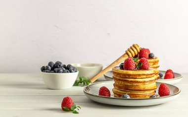 Fotokopi uzayı ile kahvaltı kavramı. Ahududulu, yaban mersinli ve ballı leziz Amerikan krepleri.. 
