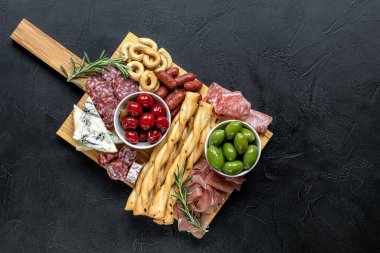 Aperatifler çeşitli İtalyan aperatifleriyle dolu. Peynir, et, zeytin ve biber. Şarküteri ve antipastel tabaklar.