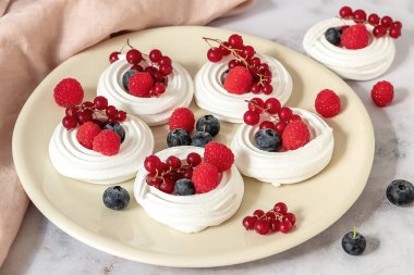 Taze kremalı pasta ya da tabakta mini Pavlova.