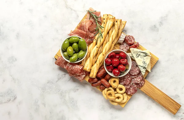 Eetbordjes met diverse Italiaanse snacks. Kaas, vlees, olijven en pepers. Charcuterie en antipasti schotel — Stockfoto