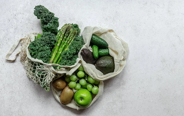 Zero waste concept. Eco bags with green fruits and vegetables. Eco-friendly shopping.