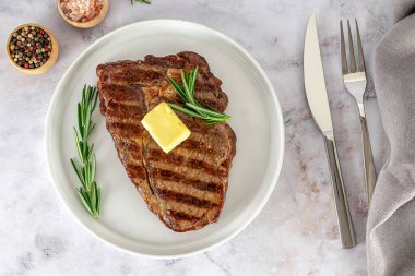 Pirzola ya da pirzola orta boy biftek, ızgarada tereyağı ve baharatla pişirilmiş mermer et. en üstteki görünüm