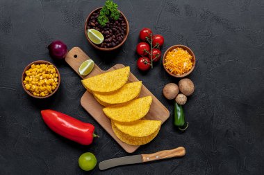 Mantarlı, fasulyeli, biberli, mısırlı ve peynirli vejetaryen taco pişirmeye hazırlanıyorum. Geleneksel Meksika yemekleri, üst manzara..