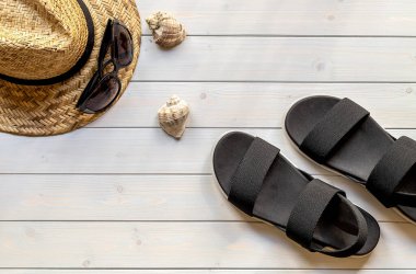 Geri dönüşümlü plastik lifler, hasır şapka, güneş gözlüğü ve deniz kabuklarından açık ayak parmaklı siyah sandaletler. 