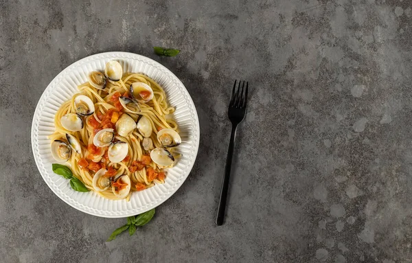 Pasta de espaguetis con almejas al vapor. Receta de mariscos italianos de cocina fresca con tomates, ajo y vino blanco — Foto de Stock