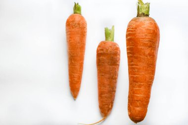 Beyaz arka planda havada taze taze taze havuçlar uçuşuyor. Yiyecek uçurma konsepti. Sağlıklı yiyecekler, olgun sebzeler. Boşluğu kopyala