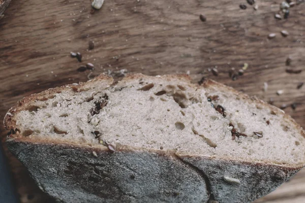 Fresh whole grain bread on a cutting board. Slices of bread with grains on a wooden board. Natural background. Copy space