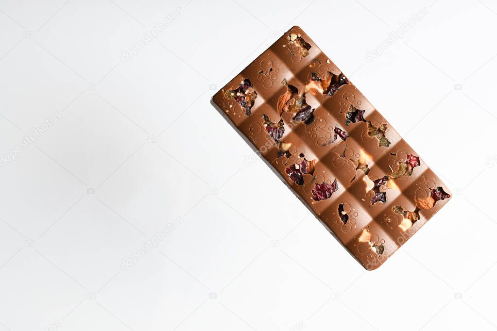 Chocolate levitation bar with fruit filling on a white background.   Food levitation concept. Flat deck chair, top view, copy space