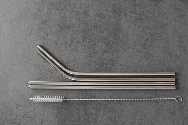 metal straws with a cleaning brush on a gray background.Ecological product, absolutely safe clean environment.