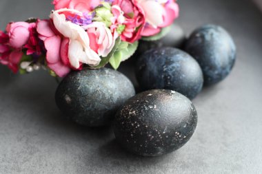 Kara Paskalya yumurtaları parlak çiçeklerle doğal boyalarla boyanır. Paskalya festivali arka planı, açık kart, yumurtalar yakın plan.