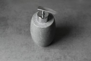 Sıvı sabun için seramik kap. Gri arka planda gri taşımsı bir şeker kutusu var. El hijyeni.