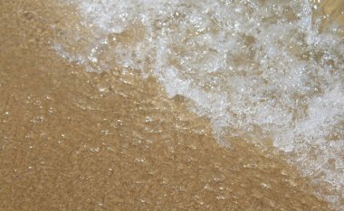 Bir yaz günü dalgalar sahile vurur.