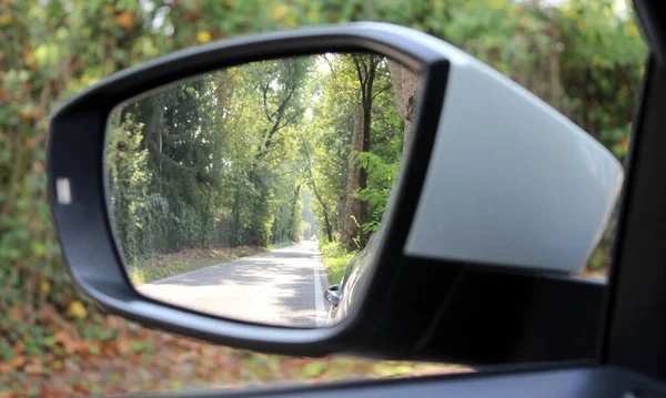 Rearview mirror of the car - driving in the countryside