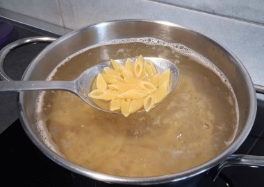 Mutfakta bir kap makarna ve kaynar su.