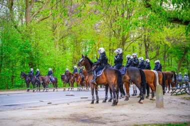 BRÜKSEL, BELGIUM - 1 Mayıs 2021: Covid-19 kısıtlamalarına karşı Brüksel Bois de la Cambre Parkı 'ndaki gezginler. Polis, La Boum adlı bir etkinlikte insanları dağıtmak için atlar, göz yaşartıcı gaz ve su topu kullandı.