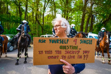 BRÜKSEL, BELGIUM - Mayıs 12021 - Covid-19 kısıtlamalarına karşı Brüksel Bois de la Cambre Parkı 'nda gezginler. Polis, La Boum adlı bir etkinlikte insanları dağıtmak için atlar, göz yaşartıcı gaz ve su topu kullandı.