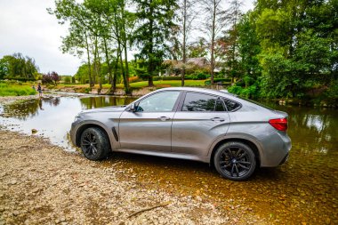 ROCHEFORT, BELGIUM - 5 Mayıs 2021: BMW X6 Gri Premium dizel araba Yazın nehir kıyısında özel plakalı