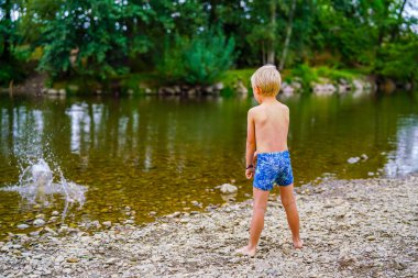 Nehir kıyısında küçük bir çocuk, yaz tatili