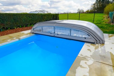 swimming pool with blue clean water and green grass