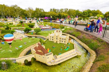 WINDSOR, BİRLİK KINGDOM - 12 HAZİRAN 2020 - Miniland 'daki turistler ve çocuklar, dünyanın dört bir yanındaki Legoland tema parkındaki anıtları ve şehirleri resmeden 40 milyon Lego tuğlasından oluşan bir minyatür park