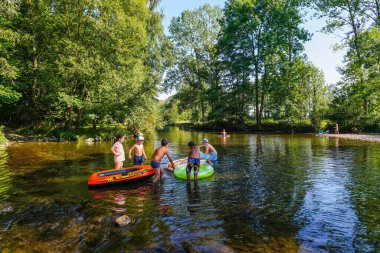 Heyecanlı ve mutlu çocuklar nehirde oynuyor ve dinleniyor.