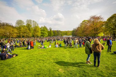 BRÜKSEL, BELGIUM - 1 Mayıs 2021: Covid-19 kısıtlamalarına karşı Brüksel Bois de la Cambre Parkı 'ndaki gezginler. Polis, La Boum adlı bir etkinlikte insanları dağıtmak için atlar, göz yaşartıcı gaz ve su topu kullandı.