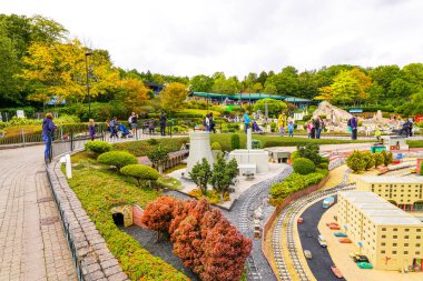 WINDSOR, BİRLİK KINGDOM - 12 HAZİRAN 2020 - Miniland 'daki turistler ve çocuklar, dünyanın dört bir yanındaki Legoland tema parkındaki anıtları ve şehirleri resmeden 40 milyon Lego tuğlasından oluşan bir minyatür park