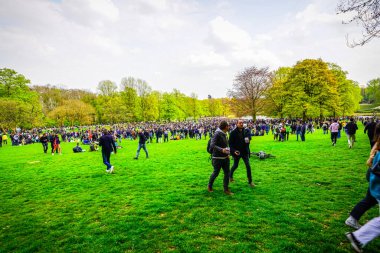 BRÜKSEL, BELGIUM - 1 Mayıs 2021: Covid-19 kısıtlamalarına karşı Brüksel Bois de la Cambre Parkı 'ndaki gezginler. Polis, La Boum adlı bir etkinlikte insanları dağıtmak için atlar, göz yaşartıcı gaz ve su topu kullandı.