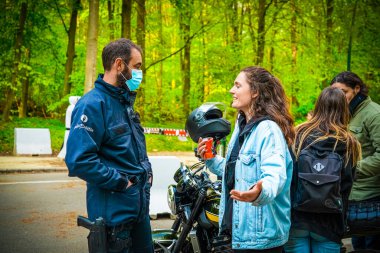 BRÜKSEL, BELGIUM - 1 Mayıs 2021: Covid-19 kısıtlamalarına karşı Brüksel Bois de la Cambre Parkı 'ndaki gezginler. Polis, La Boum adlı bir etkinlikte insanları dağıtmak için atlar, göz yaşartıcı gaz ve su topu kullandı.