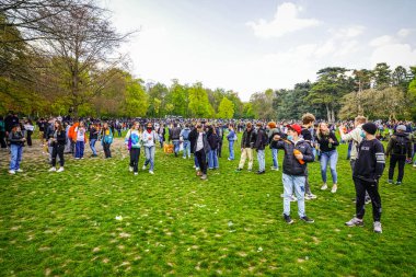 BRÜKSEL, BELGIUM - 1 Mayıs 2021: Covid-19 kısıtlamalarına karşı Brüksel Bois de la Cambre Parkı 'ndaki gezginler. Polis, La Boum adlı bir etkinlikte insanları dağıtmak için atlar, göz yaşartıcı gaz ve su topu kullandı.