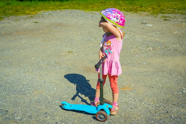 小女孩在夏天的公园里骑摩托车 — 图库照片