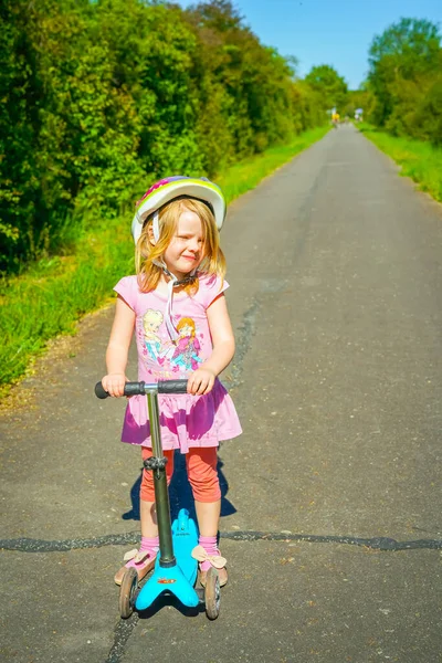 小女孩在夏天的公园里骑摩托车 — 图库照片