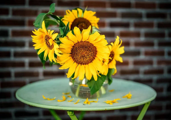 beautiful yellow sunflowers in a vase on a wooden table