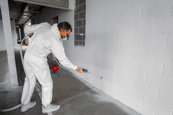 Człowiek Ogóle Malowanie Ściany Przemysłowej Białą Farbą Akrylową — Zdjęcie stockowe