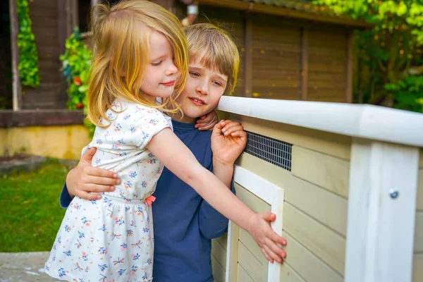 在花园的鸡舍旁 男孩和女孩拥抱着 微笑着 — 图库照片