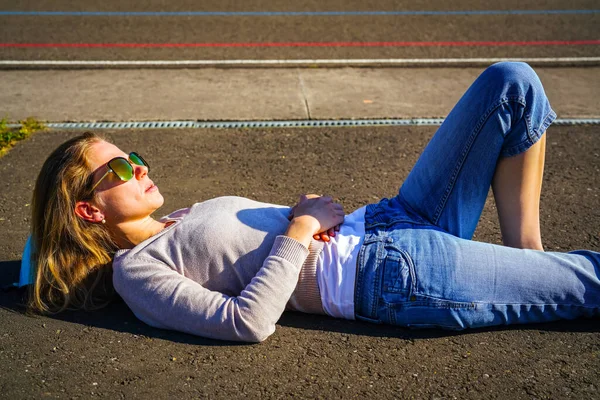 金发女人在路上躺着 放松和晒日光浴 — 图库照片