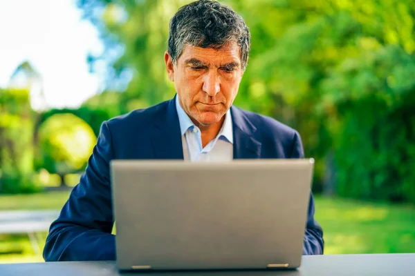 businessman working on laptop computer in the park