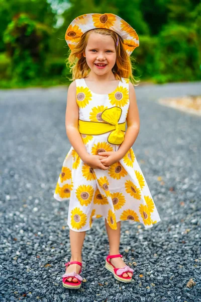 可爱的4岁金发女孩走在草地边玩耍 穿着夏日向日葵裙 — 图库照片