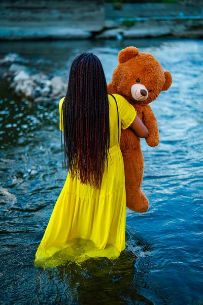 美丽的年轻女子和泰迪熊躺在河里 后视镜 — 图库照片