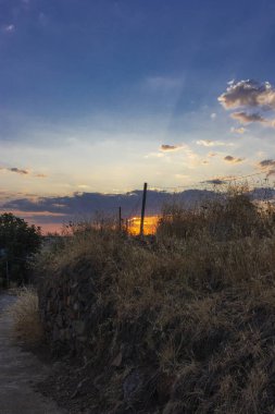 Endülüs 'teki bir tarlada taş duvar İspanya' da günbatımı gökyüzü